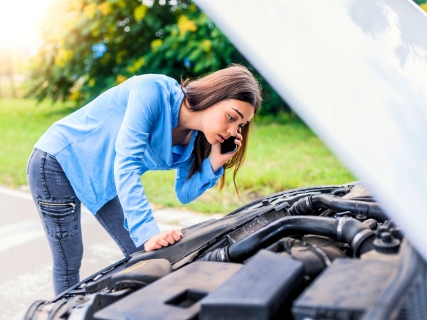 Woman Checking a Broken Down Car
